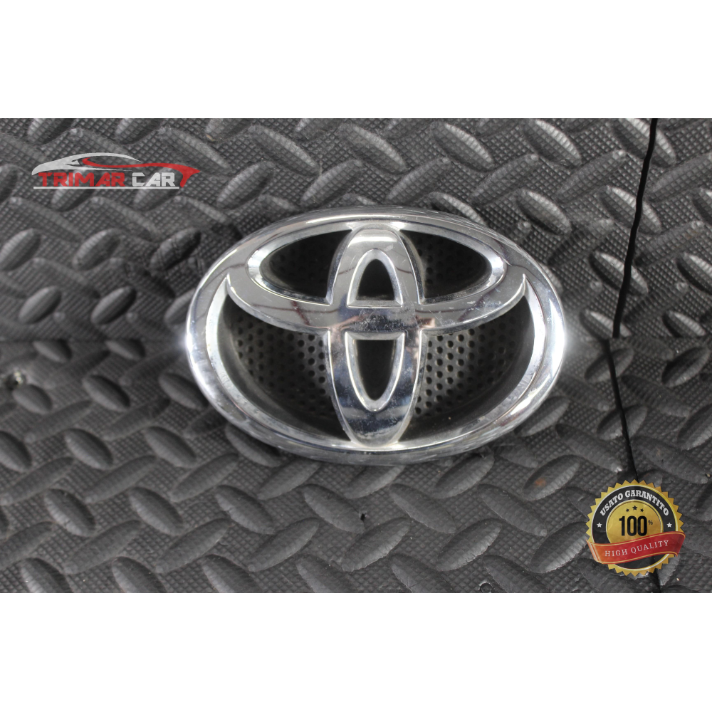 9723M0010 EMBLEMA STEMMA PARAURTI ANTERIORE TOYOTA YARIS 3 III (P13)(2010 >)